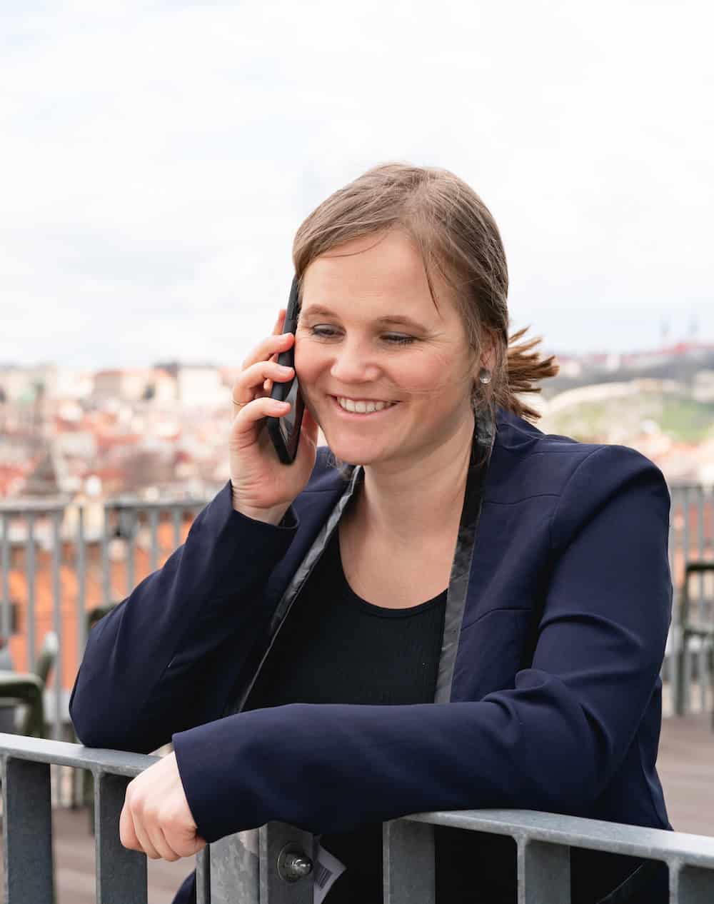 Barbora Růžičková on the phone, consulting,on a backdrop of Prague
