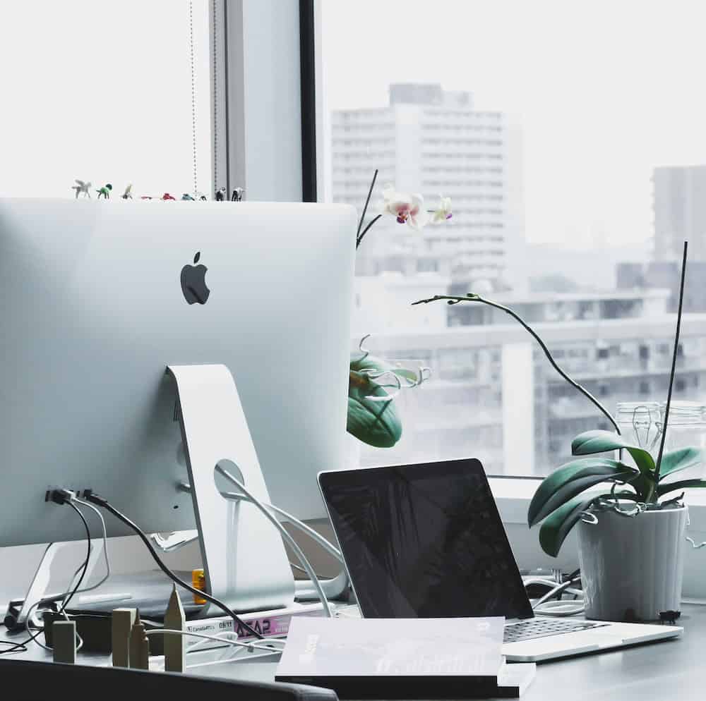 An Apple computer on a desk in an office setting