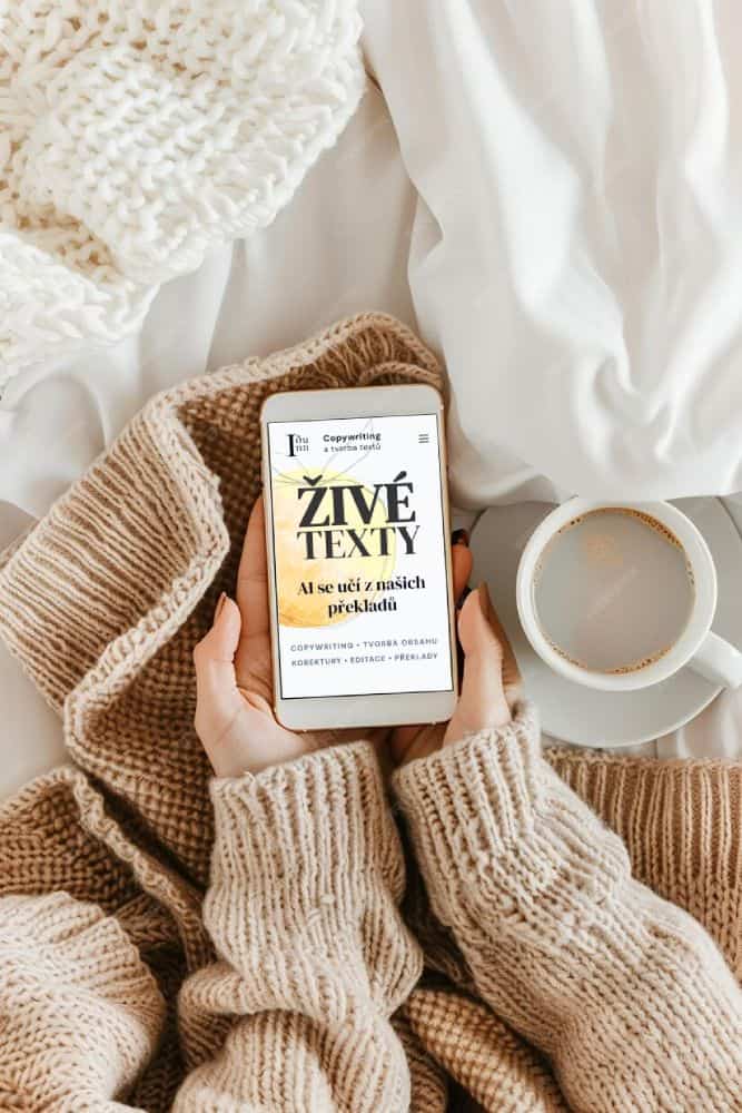 A woman's hands in a cozy hygge setting and comfortable sweater holding tablet displaying Idunn website.